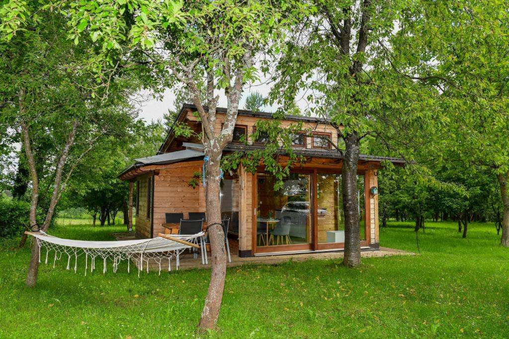 a log cabin with a hammock in the yard at Tiny House Grabovac in Rakovica