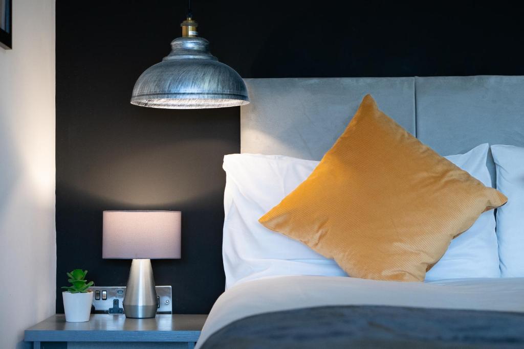 Dormitorio con cama con almohada y lámpara en Midsummer Apartments "Free On-Site Parking & Sky TV" en Peterborough
