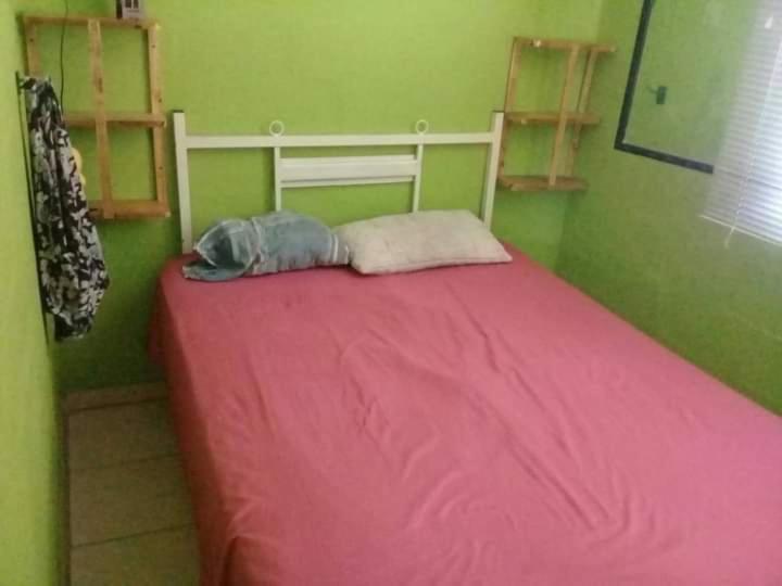 - un lit dans une chambre avec une couverture rose dans l'établissement Cabañas Mi genio amor, à San Luis