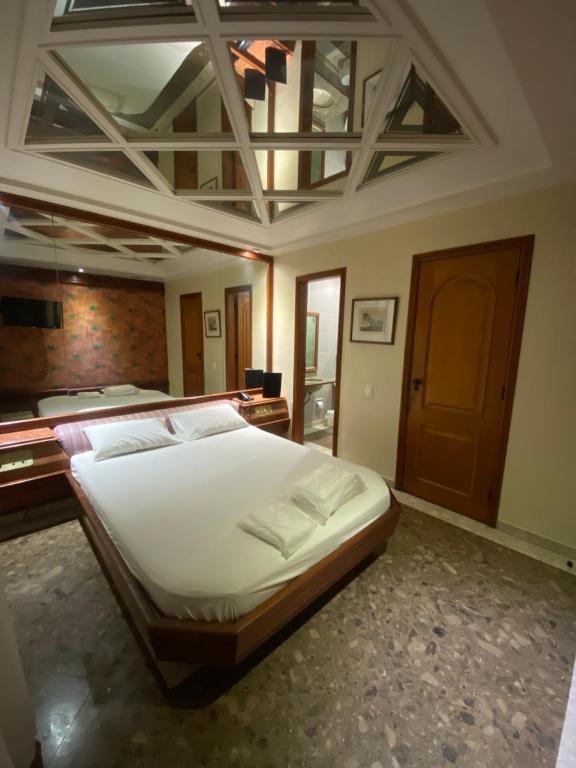 1 dormitorio con 1 cama grande y techo artesonado en Megara en Río de Janeiro