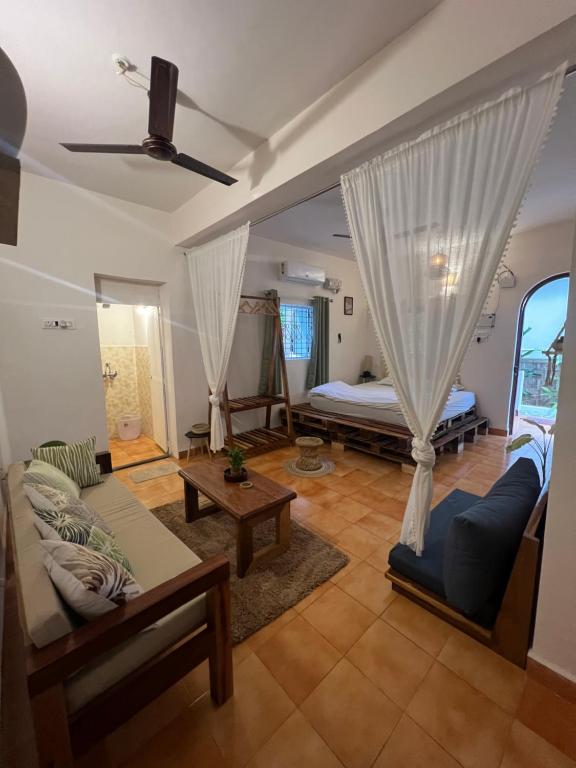 a living room with a couch and a bed at Bayou Homestay and backwaters in Goa
