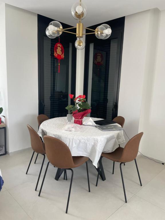 a dining room table with chairs and a chandelier at Aloni House In Dagan in Even Yehuda