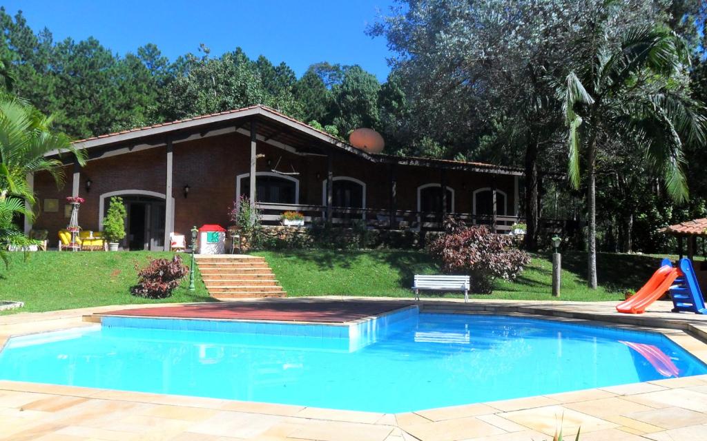 a house with a swimming pool in front of a house at APTO Refúgio Serra Negra in Serra Negra