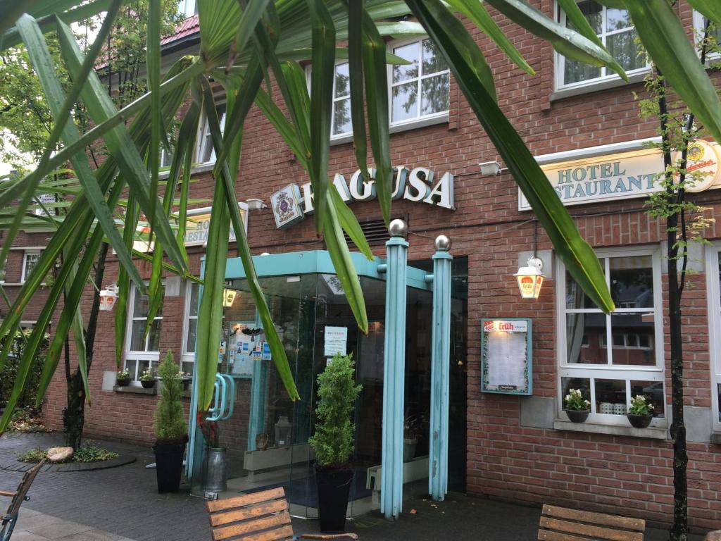 um edifício de tijolos com palmeiras em frente em Hotel Ragusa em Dormagen