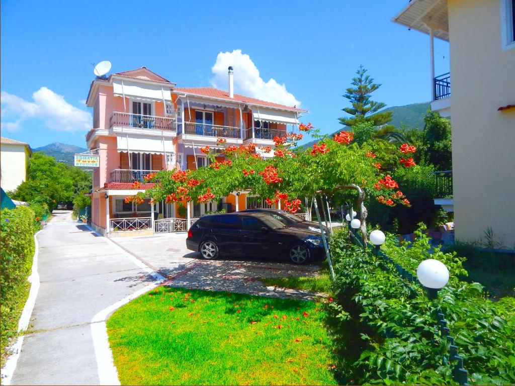 a black car parked in front of a building at Gogo's - Γωγώ Rooms & Studios in Nydri