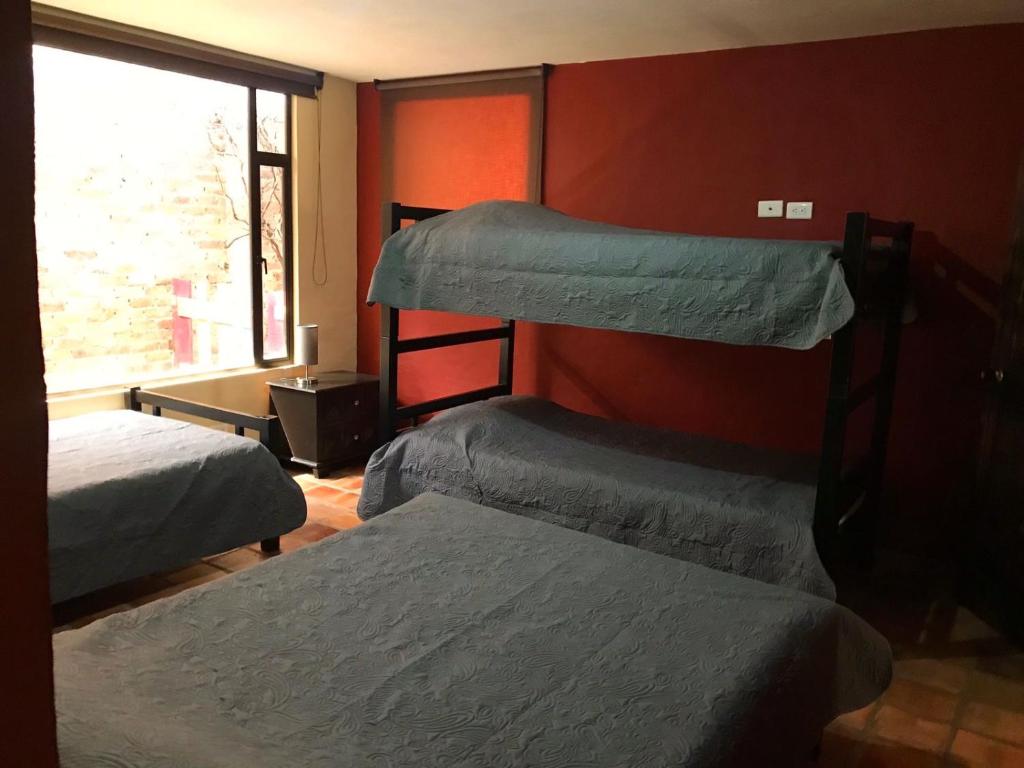 3 Etagenbetten in einem Zimmer mit Fenster in der Unterkunft Cabaña Huitaca in Paipa