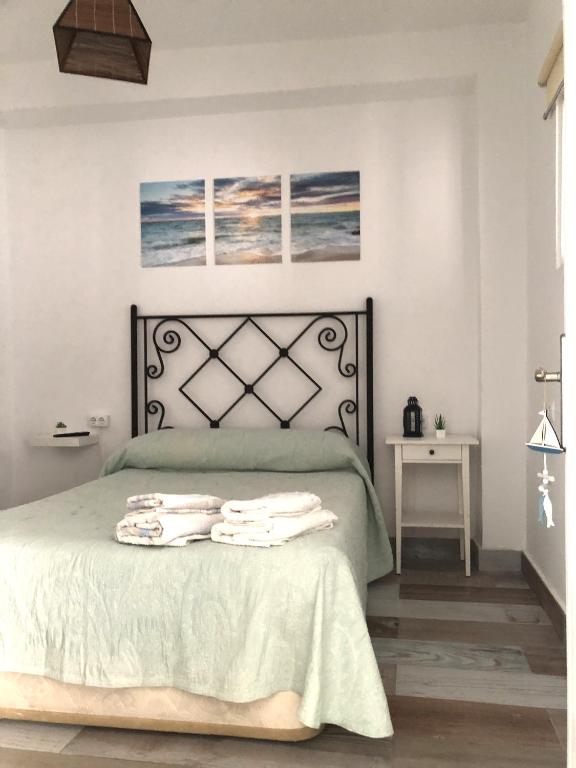 a bedroom with a bed with towels on it at Céntrico Rota Beach. in Rota
