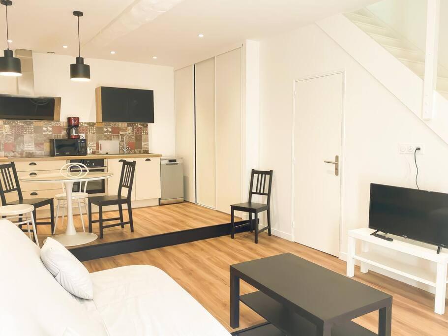 a living room with a couch and a table and a kitchen at NOUVEAU Maison Bourg Cournon 5 pers 2 chambres in Le Cendre