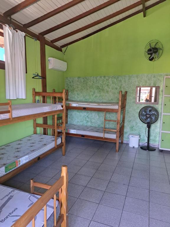 a room with three bunk beds and a fan at Girassol Hostel by Katita in Paraty
