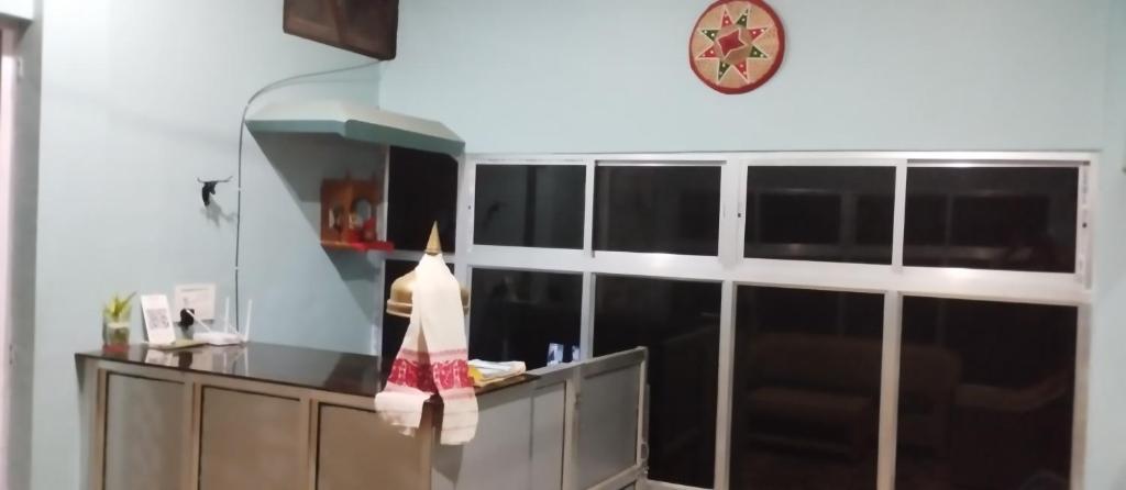 uma cozinha com um balcão e um relógio na parede em MONIRAMS INN. em Kaziranga