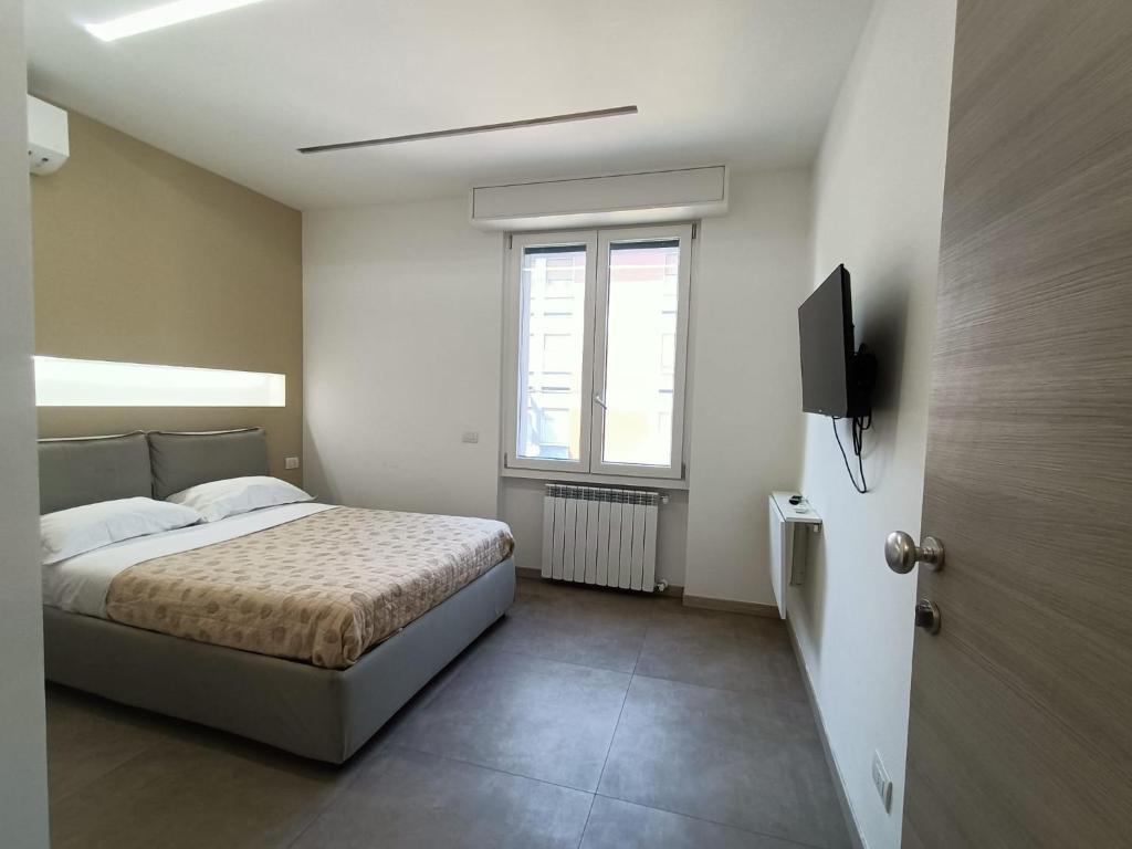 een slaapkamer met een bed, een tv en een raam bij parea house 5 in Milaan