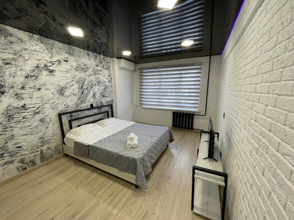 ein Schlafzimmer mit einem Bett mit einer Katze drauf in der Unterkunft 1-комнатная квартира Виноградова 12 in Öskemen