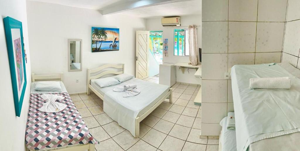 Habitación con 2 camas y mesa. en Pousada Brasil Natal, en Natal
