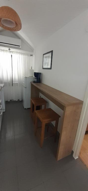 a kitchen with a wooden desk and a stool at Old Town Baska in Baška