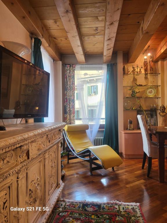 een woonkamer met een televisie en een tafel en stoelen bij Piccolo Mondo Antico in Verona