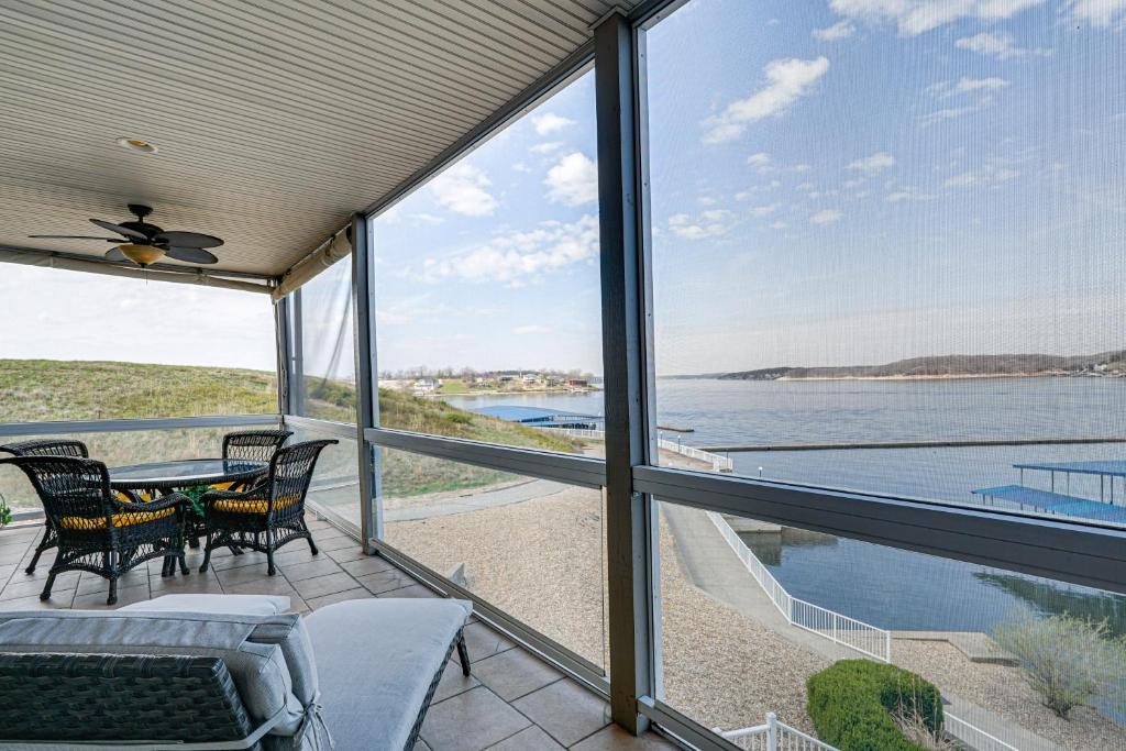 un porche con mesa y sillas y vistas al agua en Lakeside Osage Beach Condo in Lands End Community, en Osage Beach