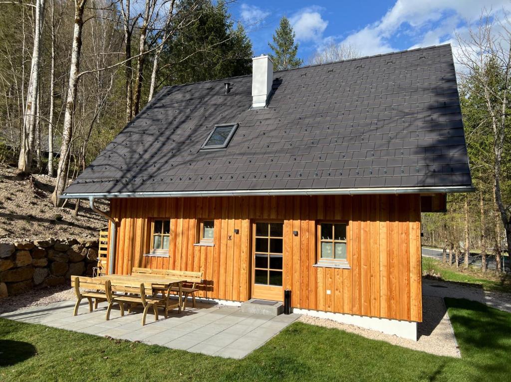 Cabaña de madera con mesa de picnic y bancos en Chalet Schäftal 