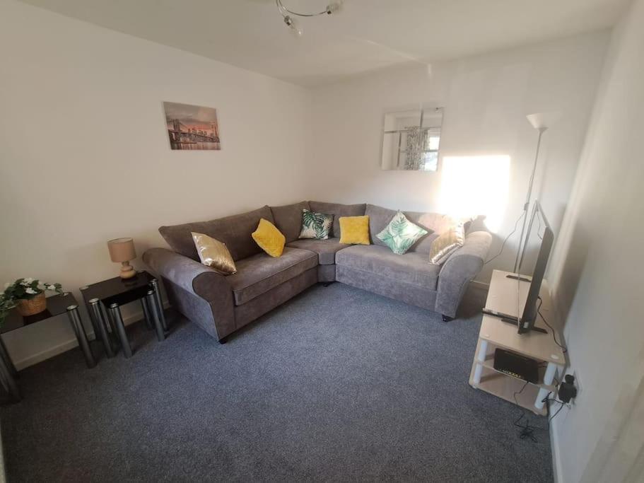 a living room with a couch and yellow pillows at 3 bedroom sleeps 4 in Glenrothes in Fife