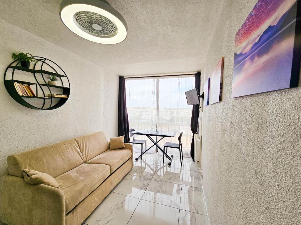 un salon avec un canapé et une table dans l'établissement CHARMANT studio proche de la mer, au Grau-du-Roi