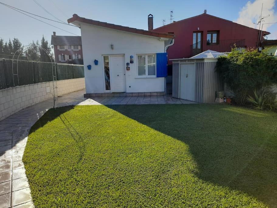 une petite maison avec une cour avec une pelouse dans l'établissement La Boquerona, à Polanco