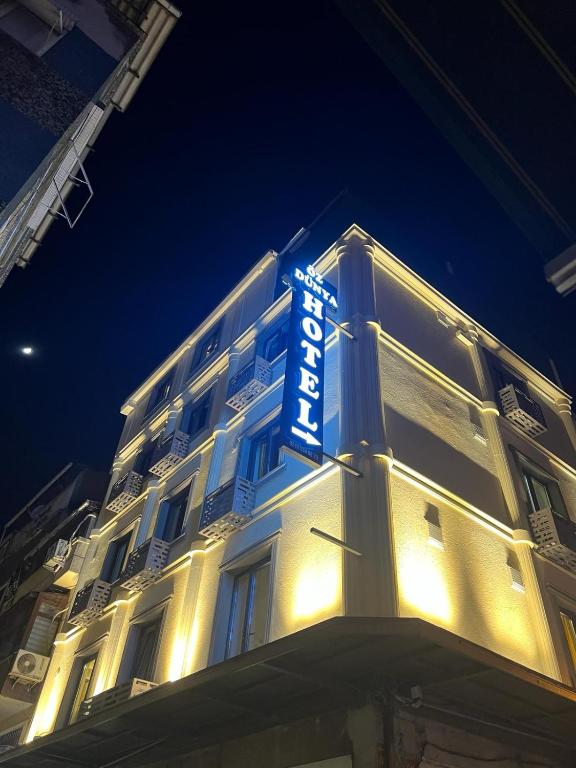 un panneau d'hôtel sur le côté d'un bâtiment la nuit dans l'établissement Öz Dünya Hotel, à Istanbul