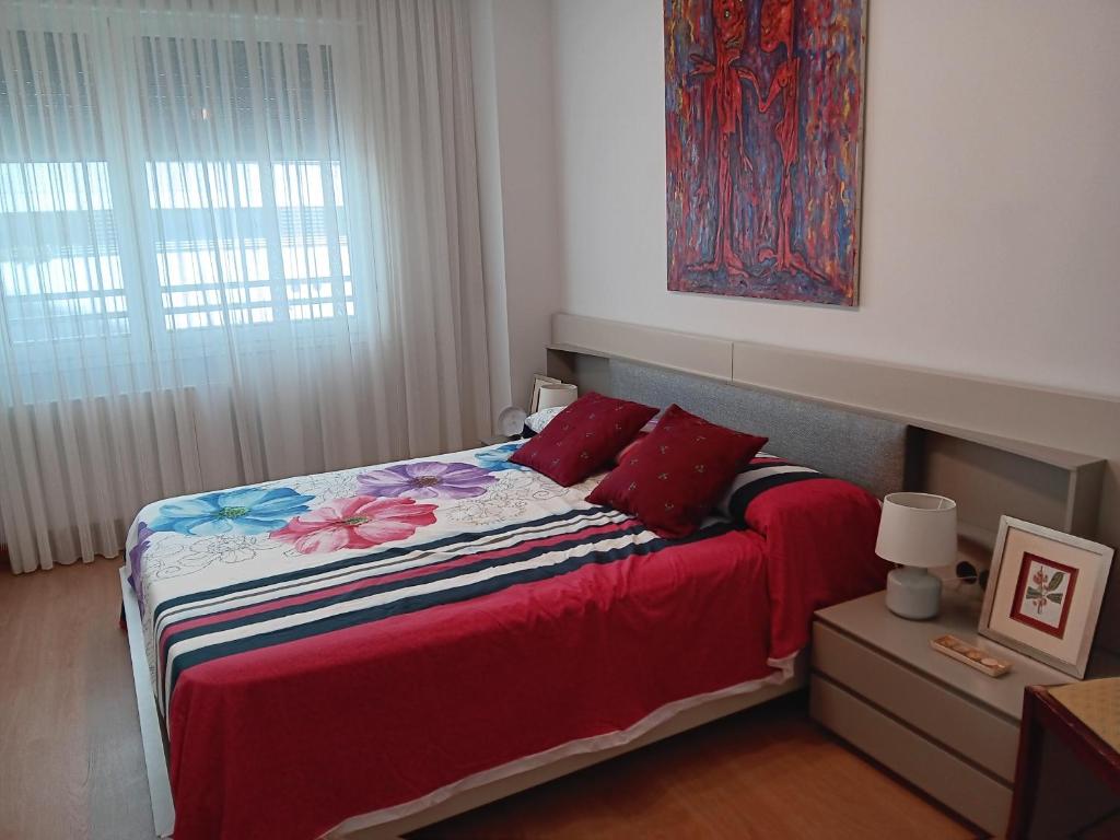 Un dormitorio con una cama con almohadas rojas y una pintura en Habitacion Bolueta Home, en Bilbao