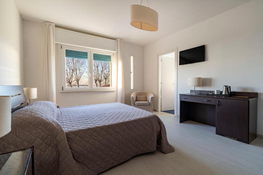 a bedroom with a bed and a desk and a window at Hotel Sorriso in Venice-Lido
