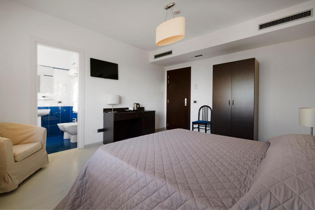 a bedroom with a bed and a chair and a desk at Hotel Sorriso in Venice-Lido