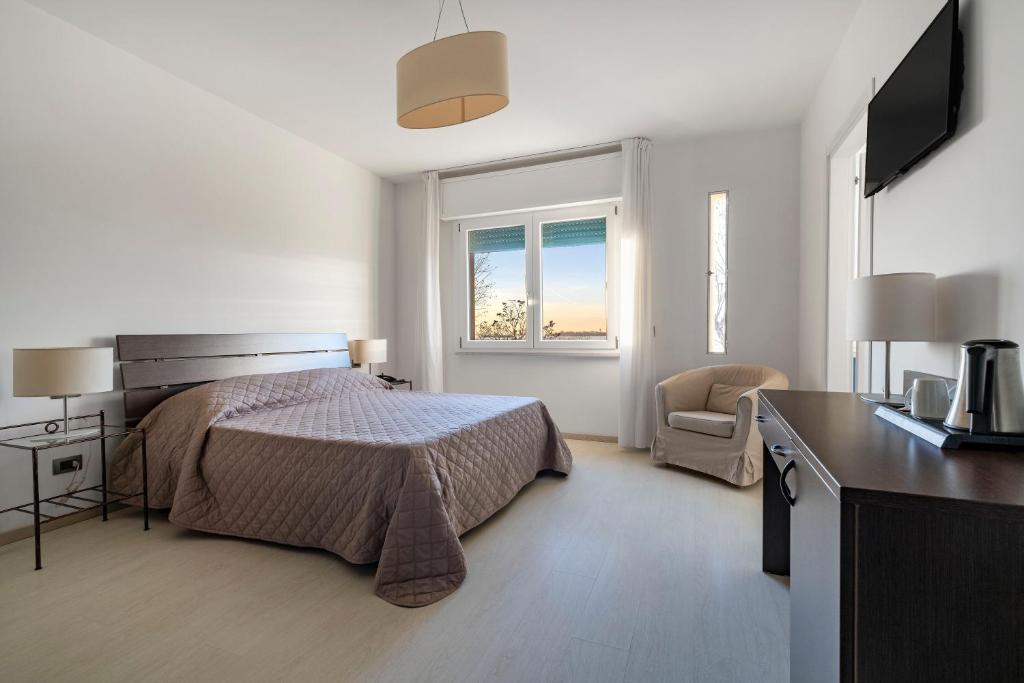 a bedroom with a bed and a desk and a window at Hotel Sorriso in Venice-Lido