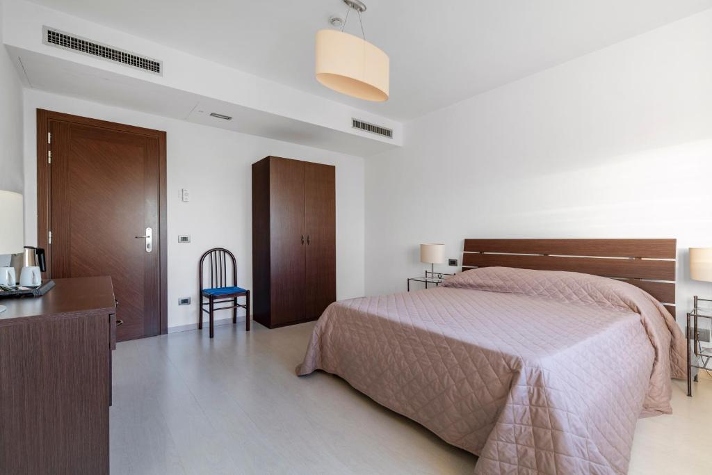 a bedroom with a bed and a desk and a chair at Hotel Sorriso in Venice-Lido
