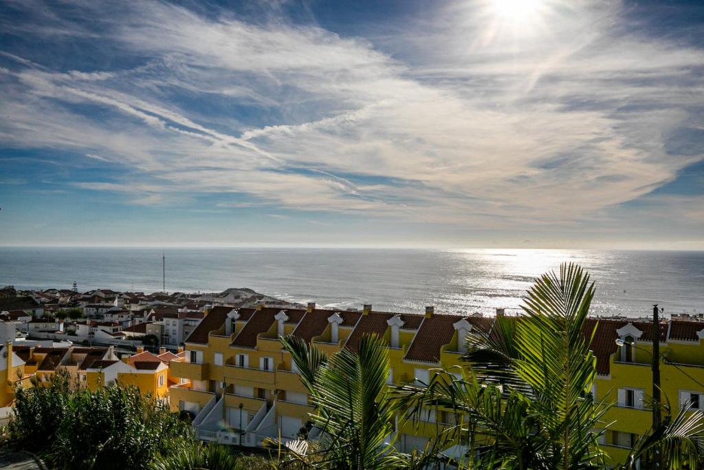 a view of a city and the ocean with buildings at Vibing & Liming Ericeira in Ericeira