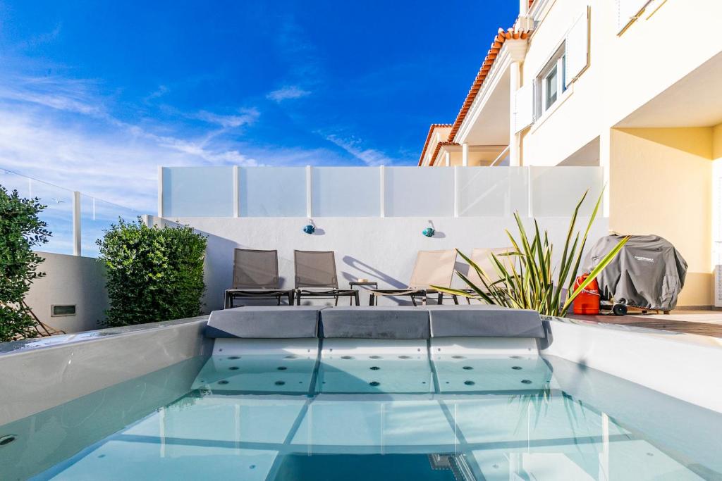 a swimming pool in the backyard of a house at Vibing & Liming Ericeira in Ericeira