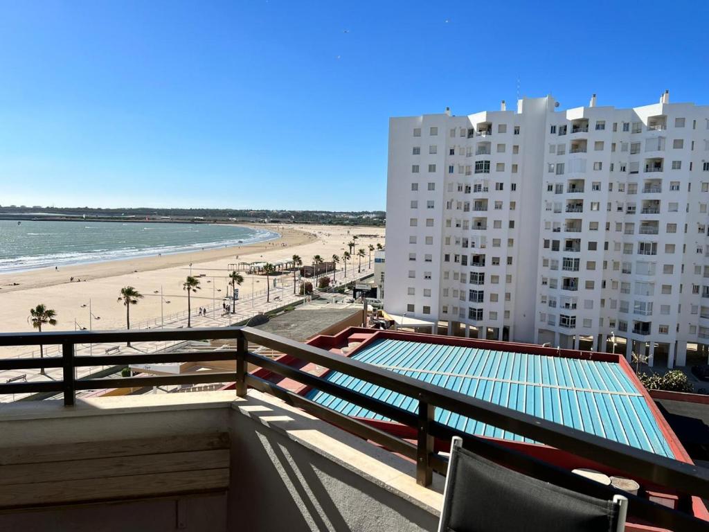 balcón con vistas a la playa y a los edificios en Vigalpe Valdelagrana 10, en El Puerto de Santa María