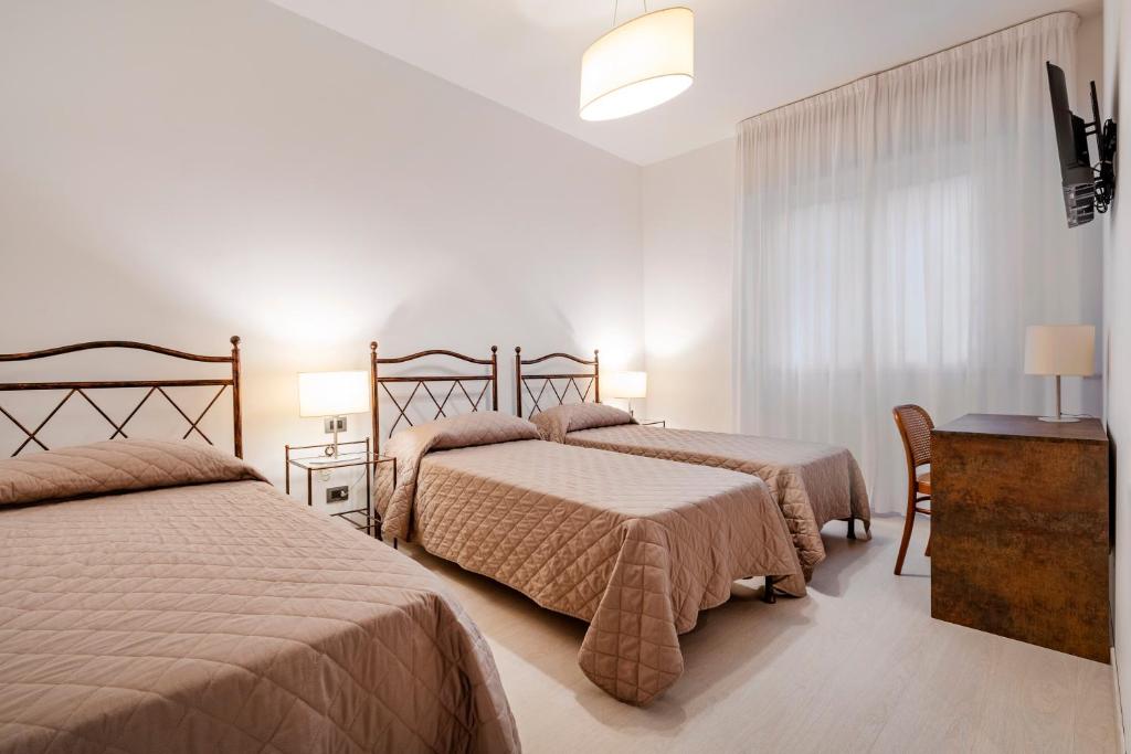 a hotel room with two beds and a window at Hotel Sorriso in Venice-Lido