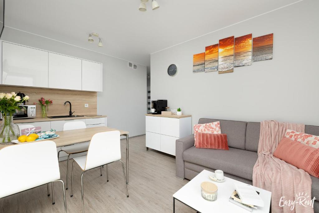 a living room with a couch and a table at Grunwaldzka 12 B22 - Easy-Rent Apartments - 50m od plaży in Pobierowo