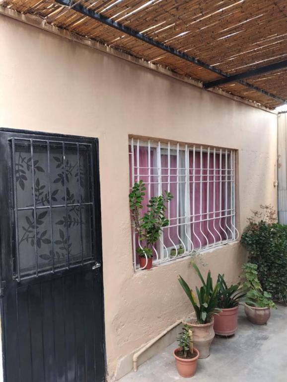 una casa con una puerta negra y una ventana en Alquiler temporario amueblado en Junín