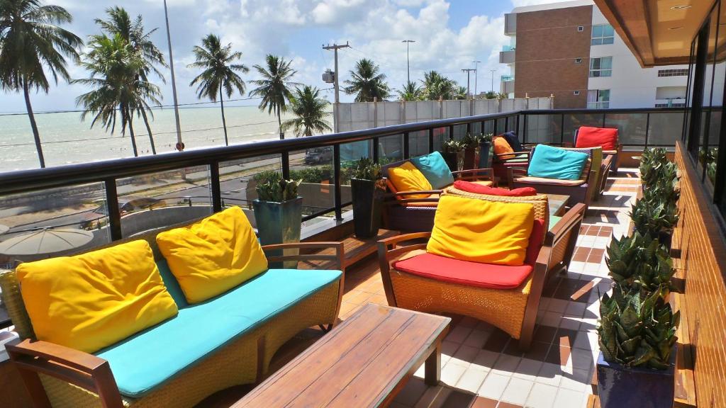 - une rangée de chaises et de tables sur un balcon avec vue sur la plage dans l'établissement Flat Mobiliado, à João Pessoa