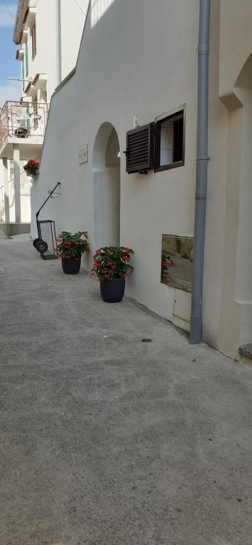 three potted plants sitting on the side of a building at Old Town Baska in Baška