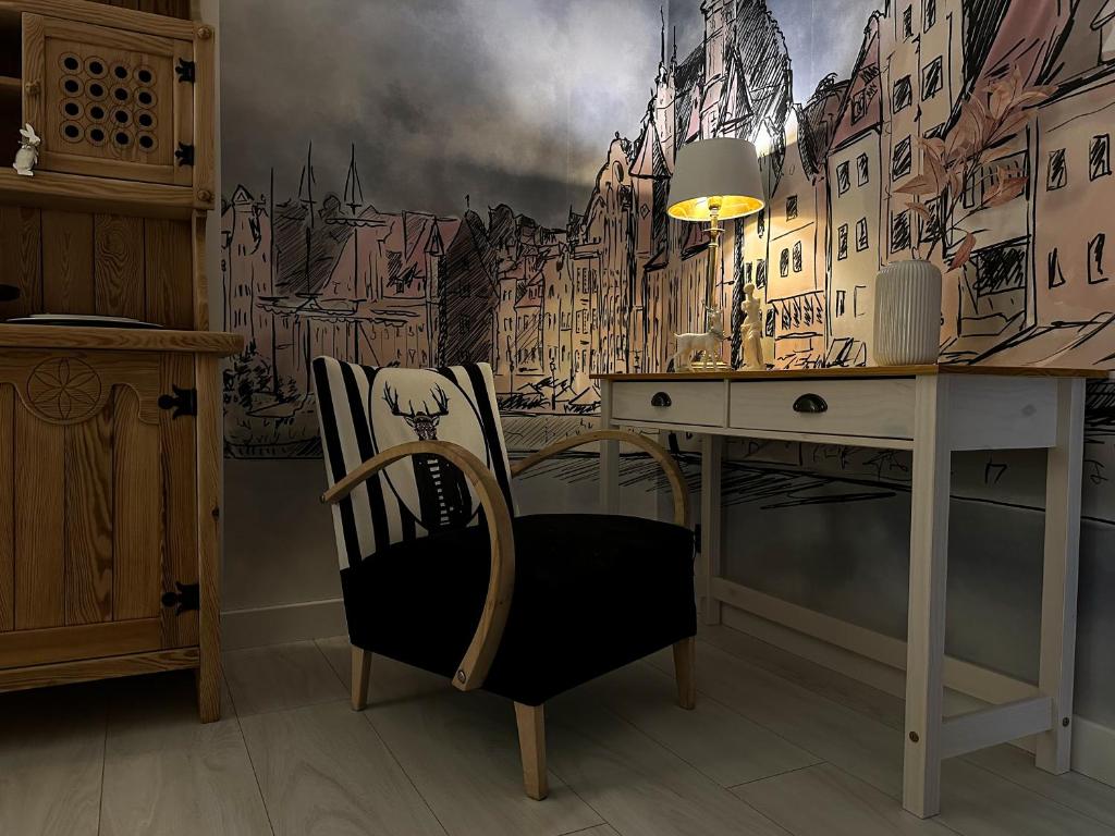 Hotel Emily, a room with a desk with a painting of a city at Emily in Toruń