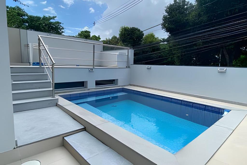 a swimming pool on a patio with stairs and a swimming poolvisor at Ampla casa com piscina na Pituba in Salvador