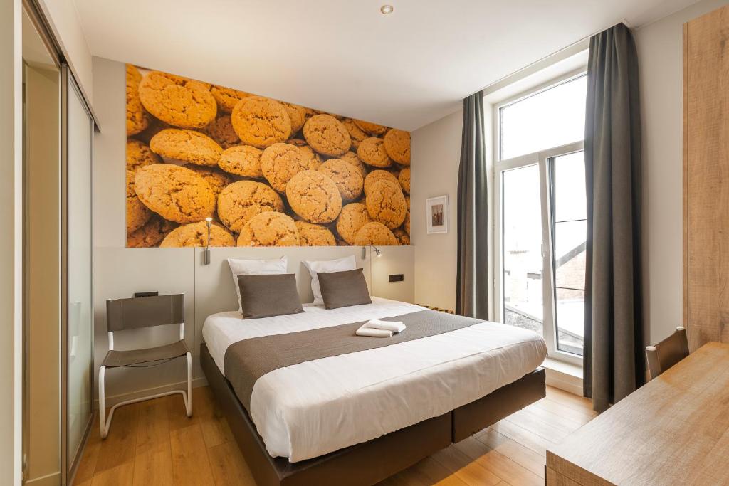 a bedroom with a bed and a wall of cookies at Hotel Het Menneke in Hasselt