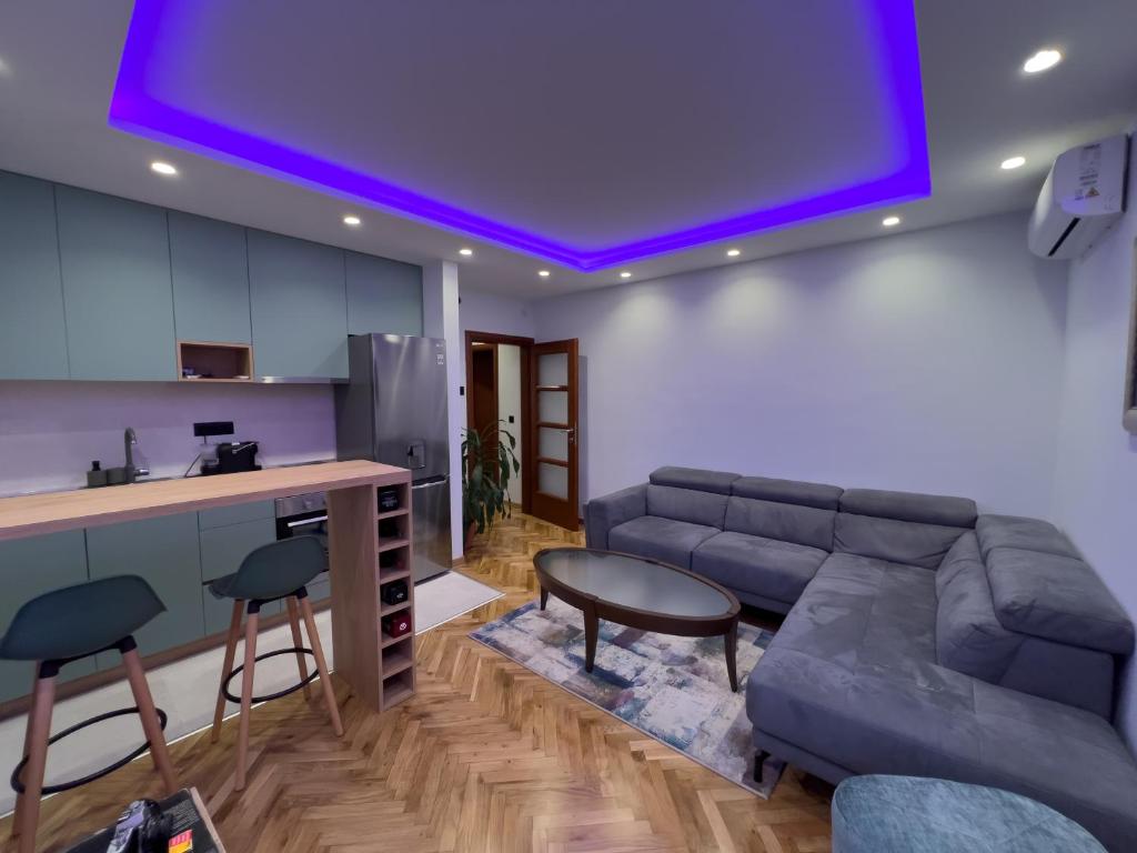 een woonkamer met een bank en een keuken bij City Gem: Stylish Urban Hideout in Budva