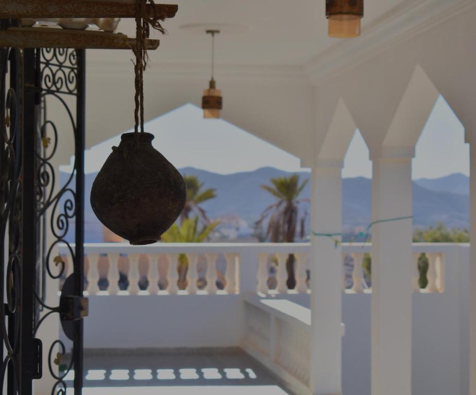 un balcón con un jarrón colgado de una barandilla en Maison d'hôtes DAR DRISS en Matmata