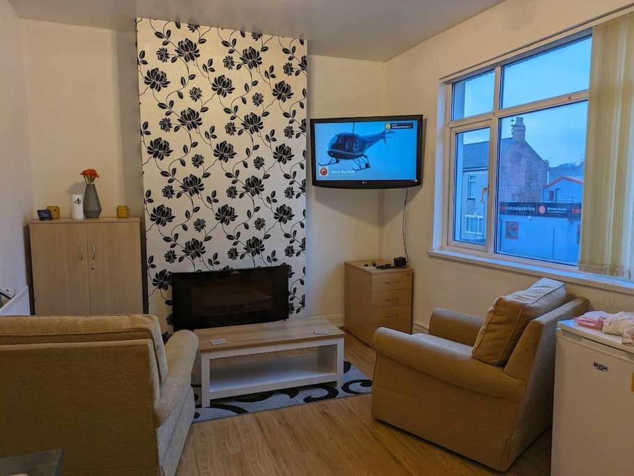 a living room with a flat screen tv and a couch and a tv at Cozy flat in Newport