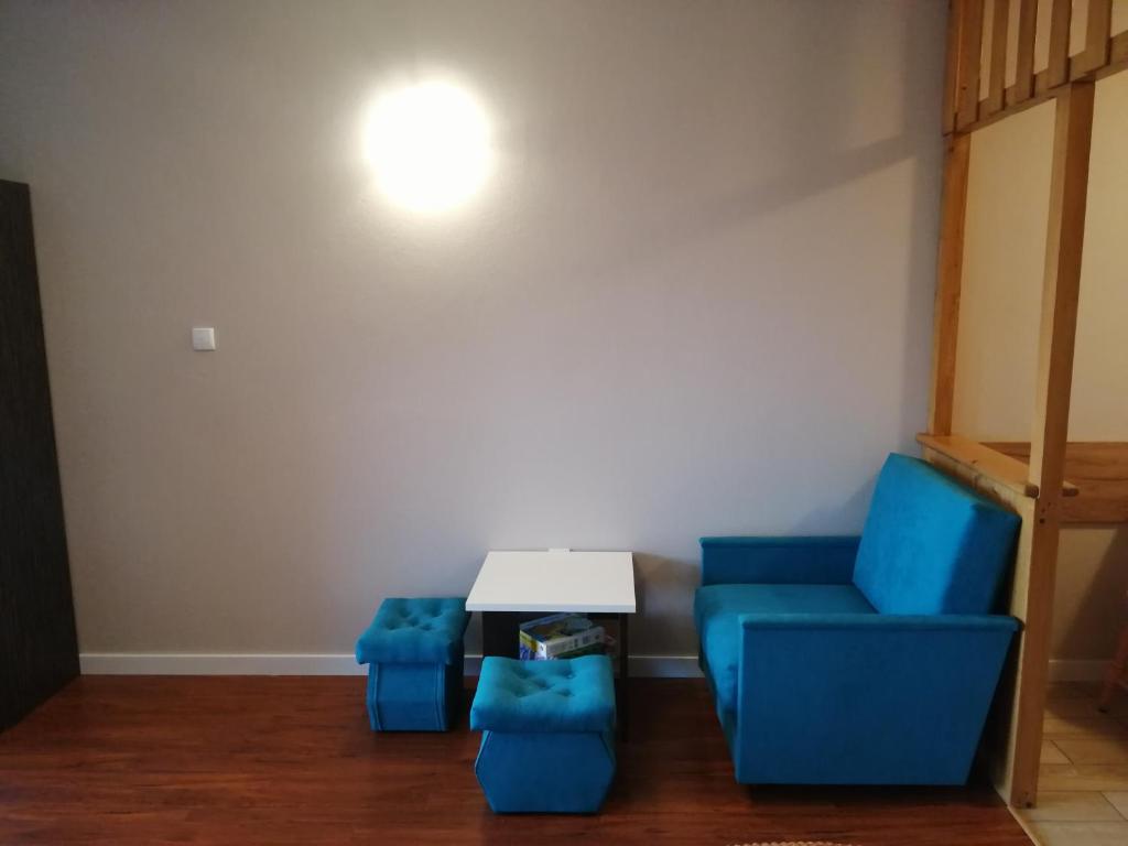Habitación con 2 sillas azules y mesa. en Agroturystyka Szklana Polana, en Huta Szklana