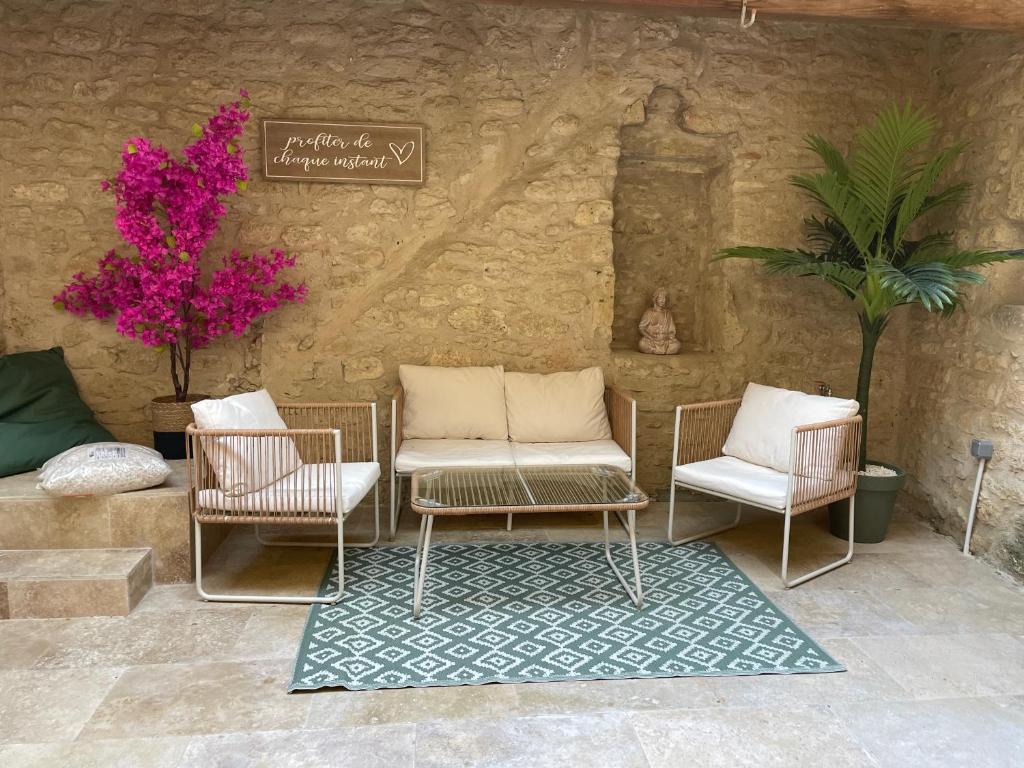 patio con 3 sedie e cartello a muro di Maison l’Oustaou Cornillonnais a Cornillon-Confoux