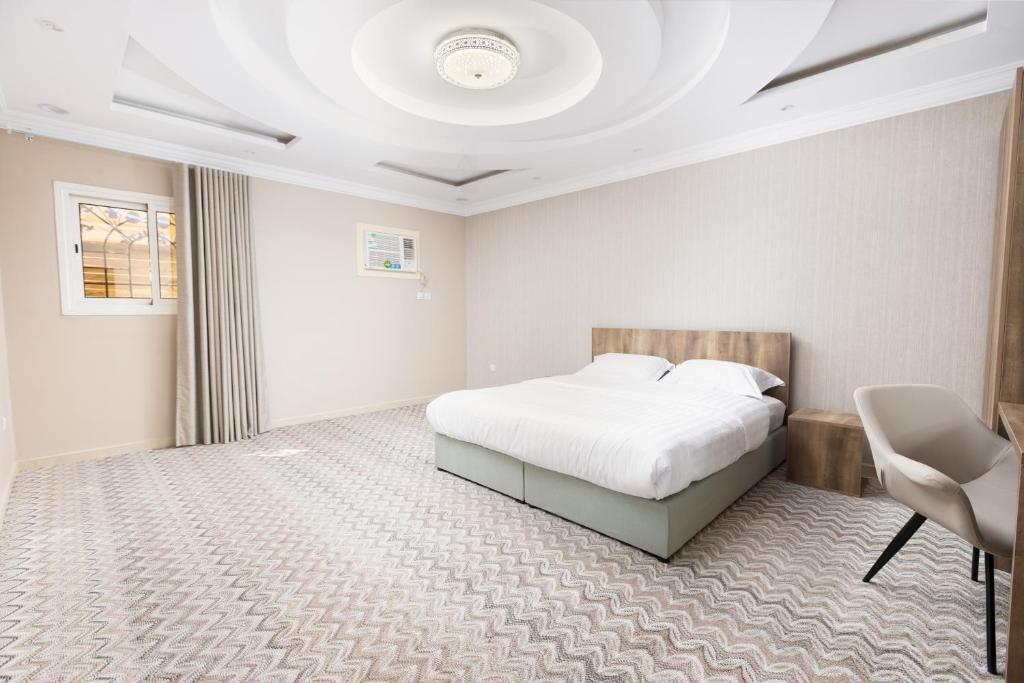 a bedroom with a bed and a desk and a chair at Al-Jamwaut A - Qaswarah Residence in Al Madinah