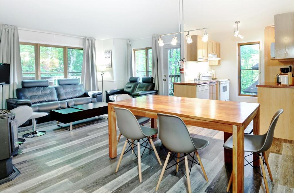 cocina y sala de estar con mesa de madera y sillas en Chalets Alpins - 07 Chemin Alpin, en Stoneham