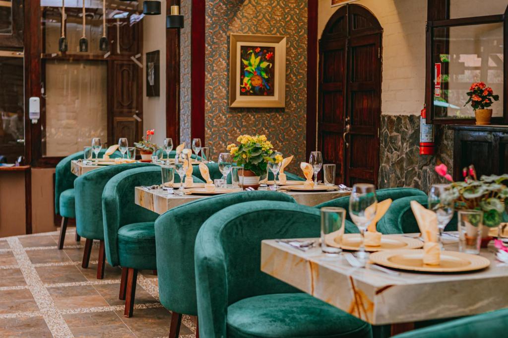 een rij tafels in een restaurant met groene stoelen bij Quinta Los Juanes in Baños