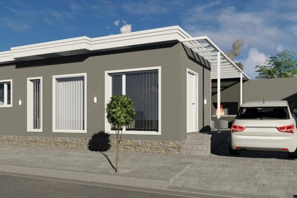 een klein huis met een auto ervoor geparkeerd bij Hermosa y amplia casa nueva in Puerto Madryn